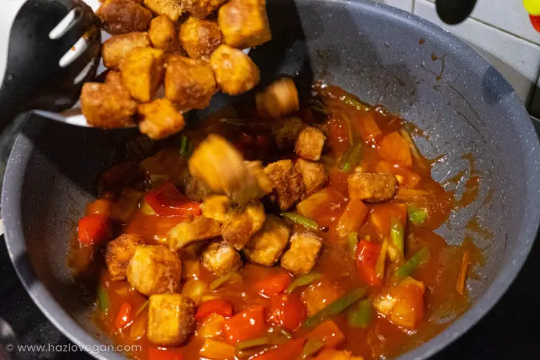 Agregando el tofu apanado a la salsa agridulce con verduras - Hazlo Vegan