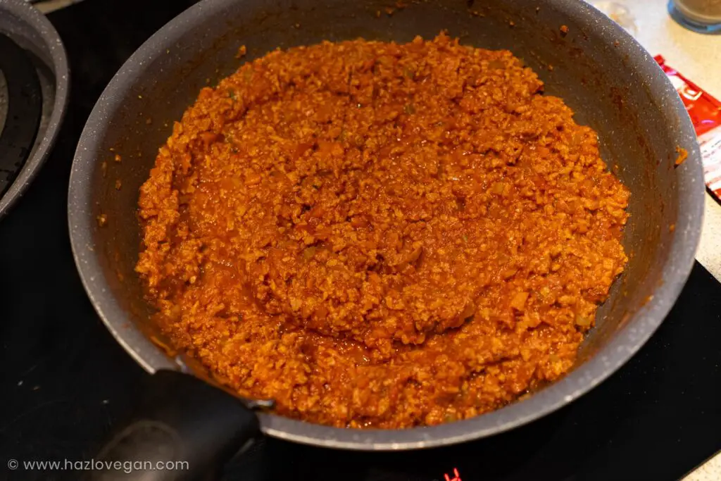 Incorporando salsa de tomate a la lasaña vegana proteica - Hazlo Vegan